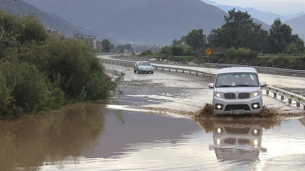 Veh&iacute;culos transitan por una v&iacute;a inundada tras las fuertes lluvias, en una fotograf&iacute;a de archivo./ EFE