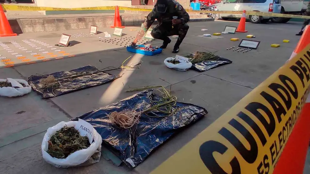 Un efectivo policial junto a parte de la droga incautada. No&eacute; Portugal