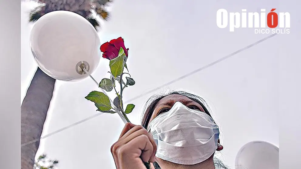 Una mujer sostiene un globo blanco y una rosa roja./ DICO SOLÍS
