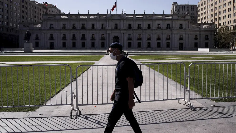 Un hombre camina usando mascarilla frente al Palacio de la Moneda de Santiago (Chile), en una fotograf&iacute;a de archivo./ EFE