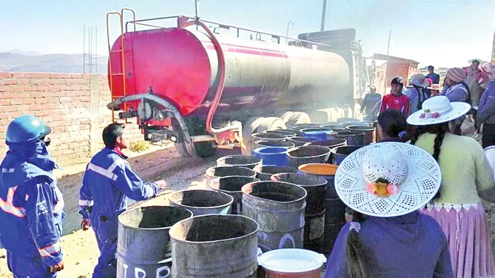 Personas hacen fila para recibir agua de una cisterna en Potos&iacute;./ EL POTOS&Iacute;