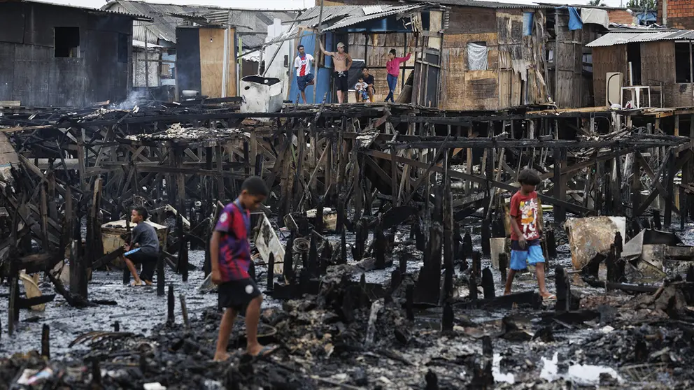 Personas observan los restos y buscan objetos tras un incendio de grandes proporciones que destruy&oacute; m&aacute;s de 100 viviendas de madera construidas sobre palafitas, hoy en Santos (Brasil)./ EFE