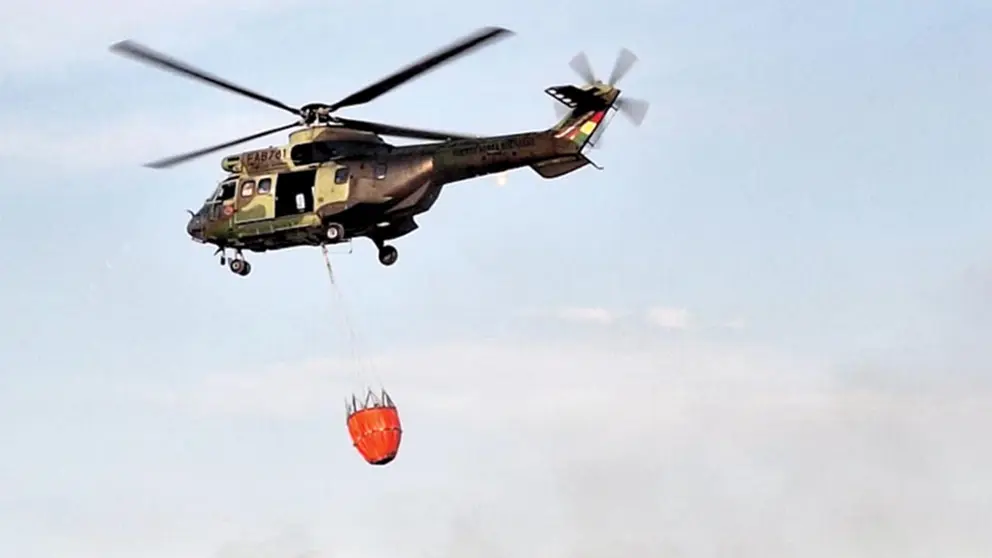 Un helic&oacute;ptero se dirige con agua a las comunidades afectadas por incendios./ MINISTERIO DE DEFENSA