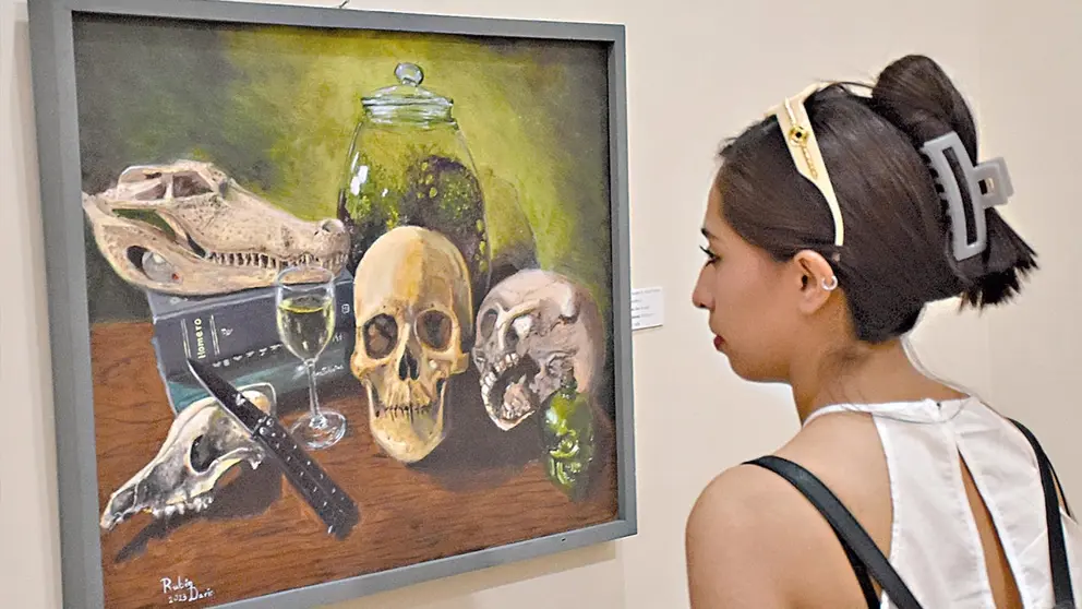 Una persona observa un cuadro en el que est&aacute;n pintados restos &oacute;seos./ NO&Eacute; PORTUGAL