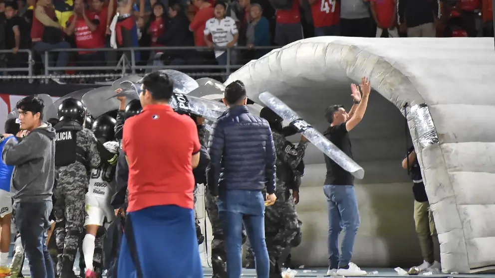 Cristian D&iacute;az (d), intentando contener los botellazos de los Gurkas, en el partido de ida entre Wilster y Bol&iacute;var, por la Copa DivPro. DICO SOL&Iacute;S