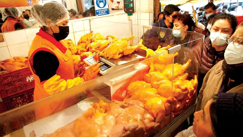 Una vendedora vende pollo en un mercado./ ABI