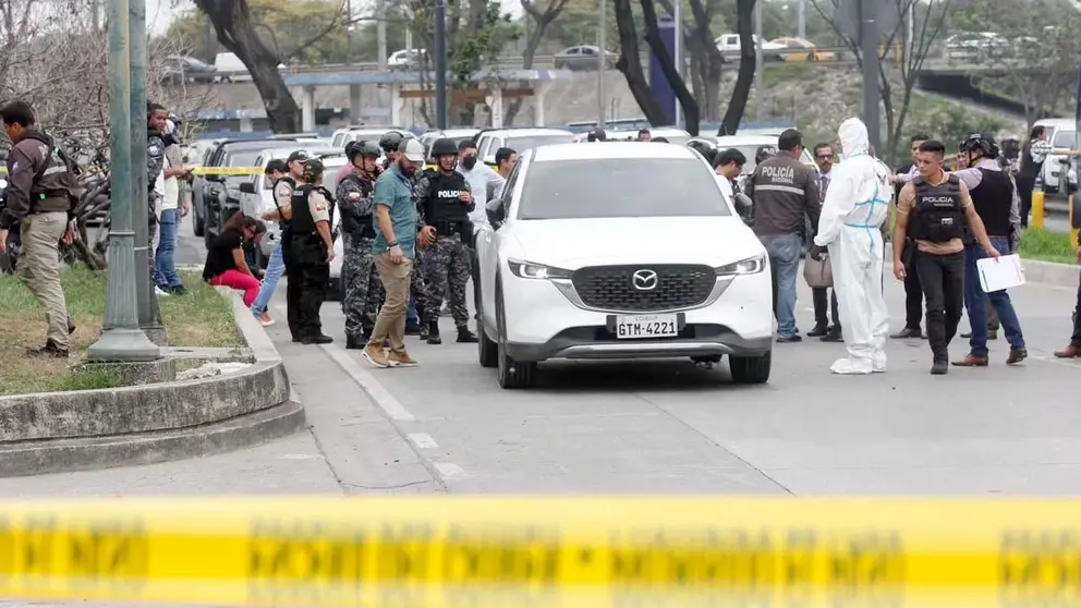 Policías investigan el vehículo con impactos de bala en el que se encontraba el fiscal César Suárez al ser asesinado./ EFE