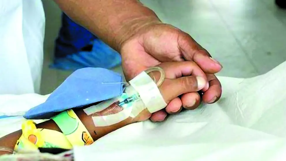 Sostienen la mano de una niña internada en un hospital./ ANF