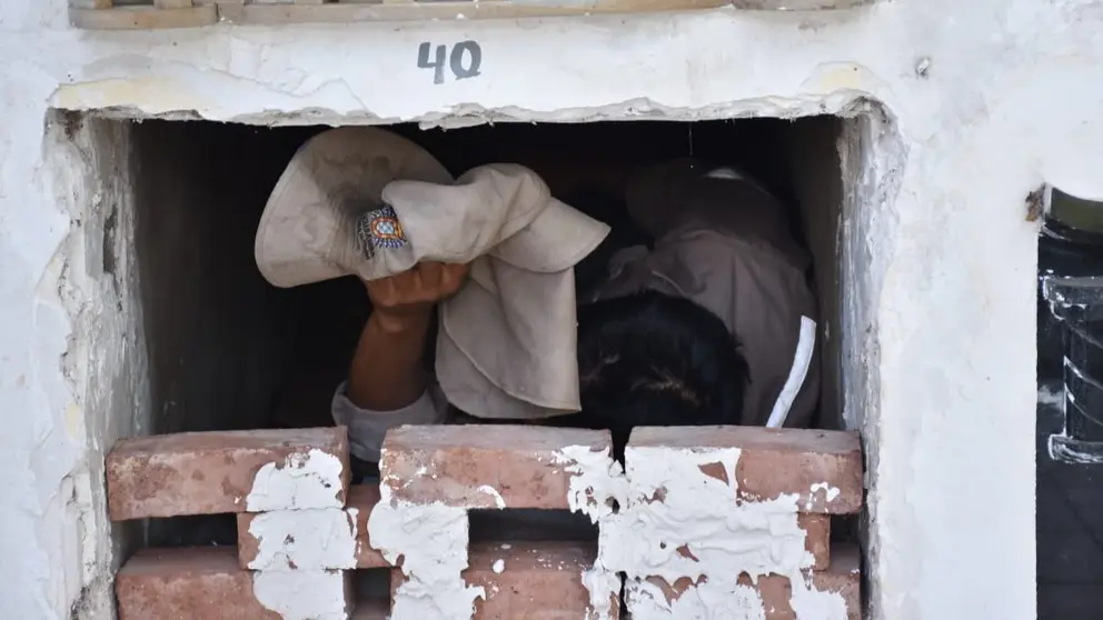 Uno de los trabajadores del Cementerio General de Cochabamba tapiado dentro de un nicho. NO&Eacute; PORTUGAL