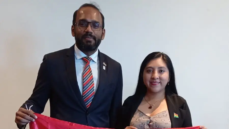 El presidente mundial de JCI, Kaveen Kumar Kumaravel (izquierda), sostiene la bandera boliviana./ JCI