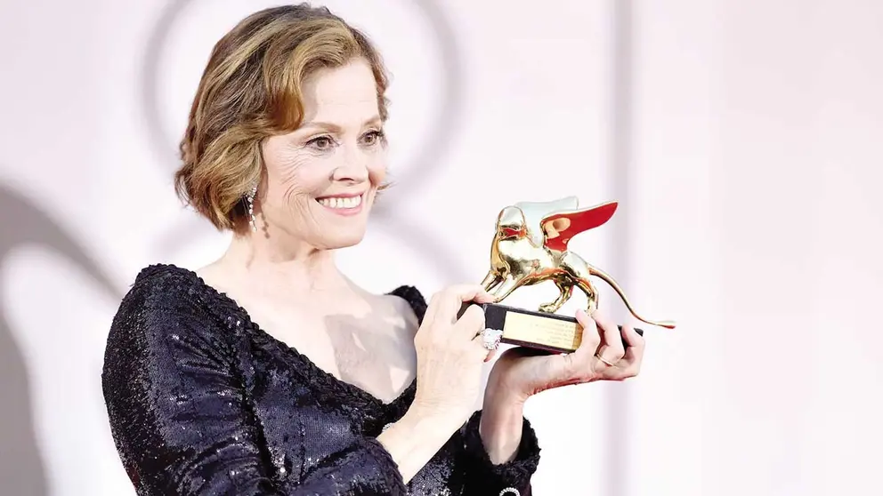 La actriz Sigourney Weaver posa con el León de Oro por su carrera artística./ EL PAÍS