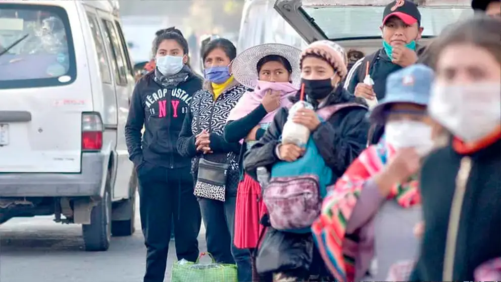 Un grupo de personas abrigadas aguarda transporte p&uacute;blico en Cochabamba. NO&Eacute; PORTUGAL