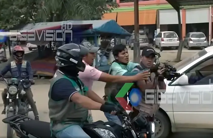 La imagen muestra el momento en que un mototaxista y un ciudadano de Villa Yapacan&iacute; intentan arrebatar una c&aacute;mara a un reportero de televisi&oacute;n. CAPTURA DE GIGAVISI&Oacute;N