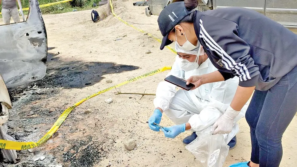 Investigadores procesan la escena donde hallaron el cuerpo de Richard y su camioneta quemada./ FISCAL&Iacute;A