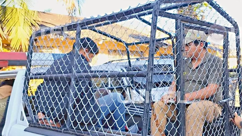 La Polic&iacute;a conduce a uno de los detenidos por el cu&aacute;druple crimen./ PEDRO SILVA/UNITEL