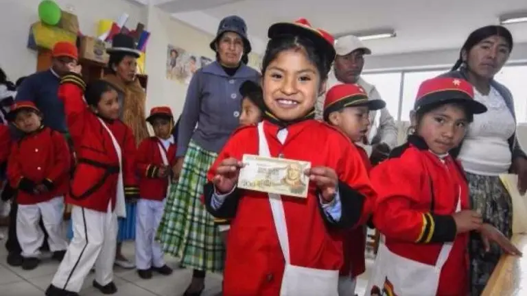Una ni&ntilde;a recibe su bono Juancito Pinto en una gesti&oacute;n anterior. ARCHIVO