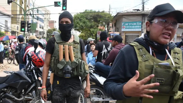 Miembros de la Resistencia Juvenil Cochala uniformados y con explosivos en un chaleco durante los d&iacute;as de paro, Milena Soto (i).