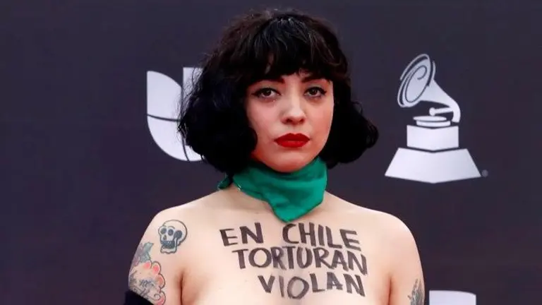 La cantante chilena Mon Laferte muestra un mensaje en pecho desnudo en la alfombra roja de los premios Latin Grammy. EFE