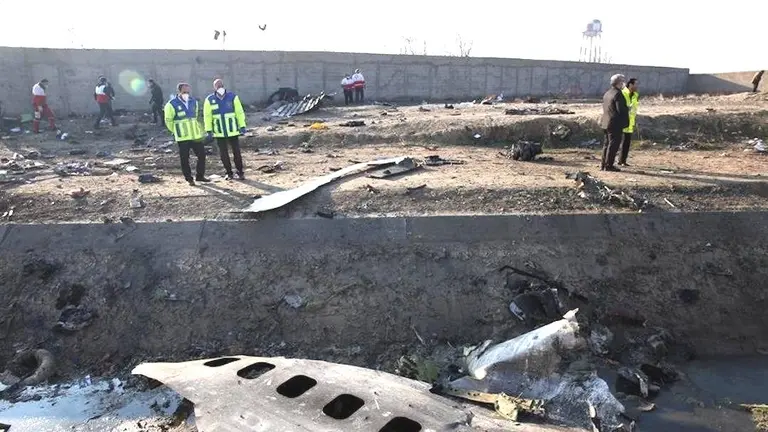 Miembros de los servicios de emergencia de Ir&aacute;n observan el avi&oacute;n estrellado.  EFE