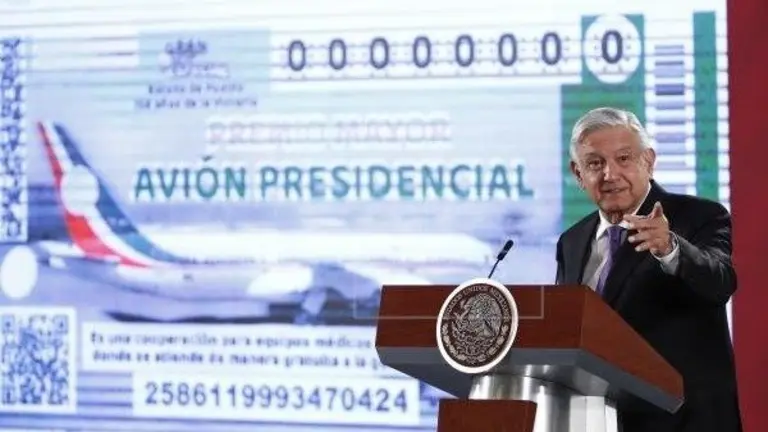 El presidente de M&eacute;xico, 
 Andr&eacute;s Manuel L&oacute;pez Obrador, presenta el boleto para la rifa del avi&oacute;n presidencial. EFE