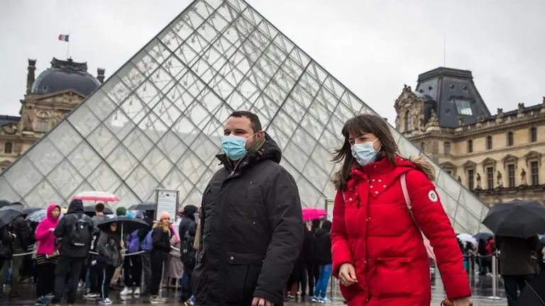 Turistas con barbijos en la puerta del Louvre, cerrado ante la expansi&oacute;n del coronavirus.    EFE