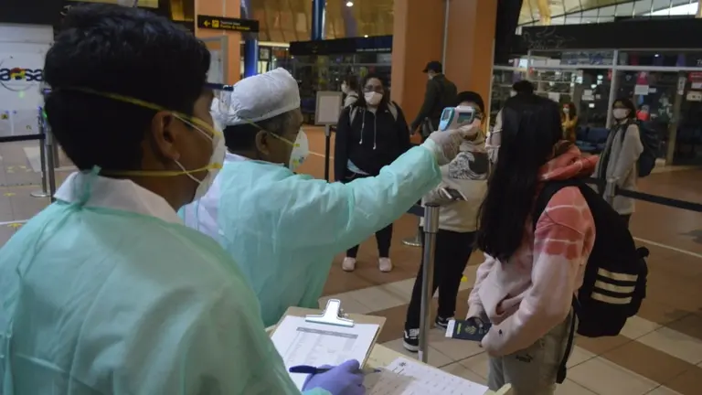 Un grupo de m&eacute;dicos examinan a varios pasajeros en el aeropuerto Jorge Wilstermann.