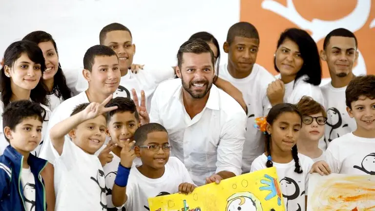 El cantante Ricky Martin posa con varios estudiantes durante la inauguración este lunes 25 de agosto del Centro educativo construido gracias a la aportación de la Fundación Ricky Martin. EFE