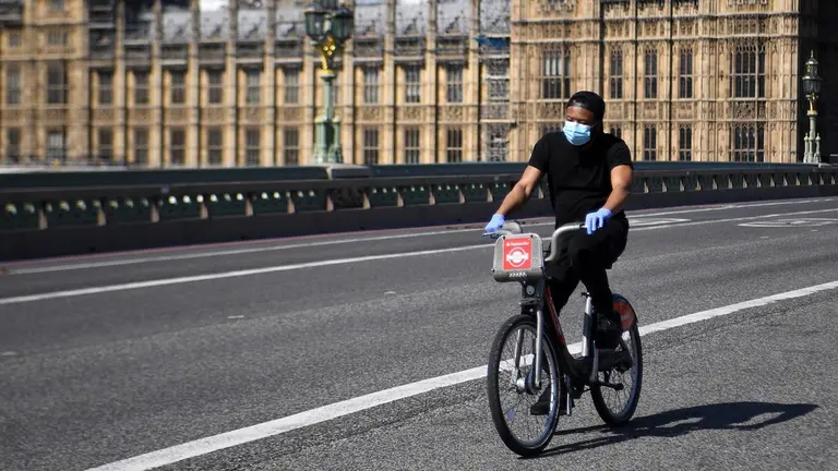 Una mujer transita las calles de Londres en bicicleta. EFE