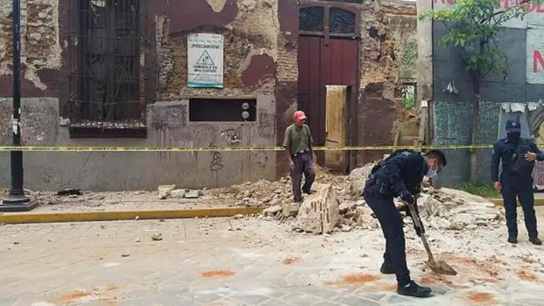 Policías y miembros de Protección Civil levantan parte de una barda derrumbada en la ciudad de Oaxaca (México). EFE 