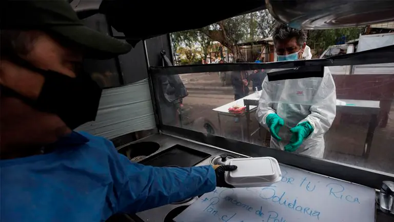 Un grupo de vecinos prepara almuerzos en una olla com&uacute;n, destinada a ayudar a las familias vulnerables y a las personas sin techo del sector afectadas por la pandemia de la COVID-19 en la comuna de Conchal&iacute; en Santiago de Chile.&nbsp;&nbsp;&nbsp;&nbsp; FUENTE: EFE