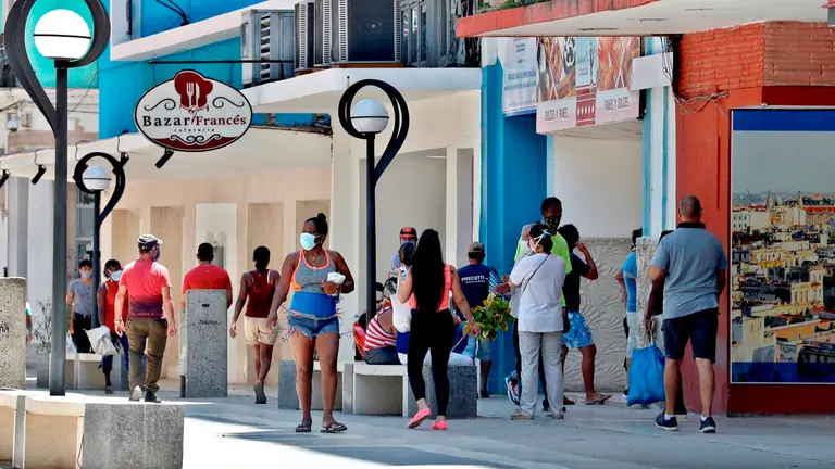 Personas con tapabocas caminan en una calle en La Habana (Cuba). EFE