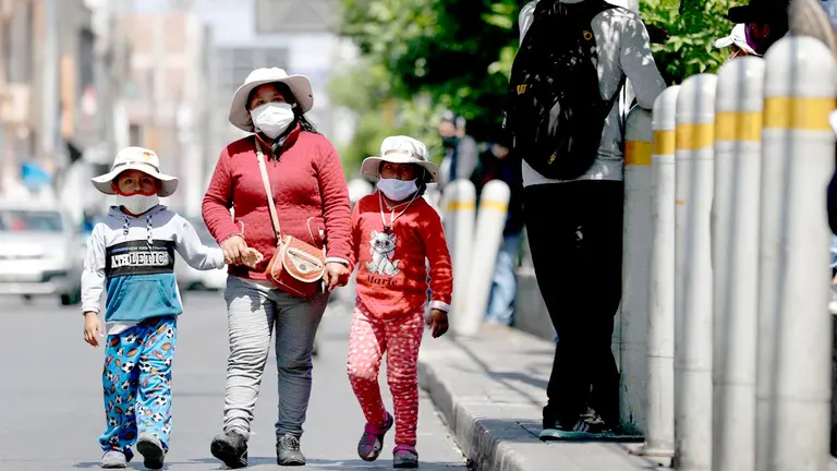 Madre con sus hijos caminan en una calle en Lima, Perú. EFE
