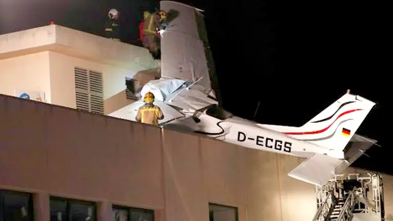 Imagen de la avioneta estrellada en lo alto de un edificio. EFE