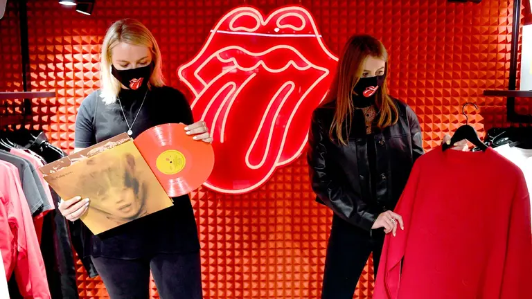 Los trabajadores posan sosteniendo una buena marca con la banda británica 'The Rolling Stones'. EFE