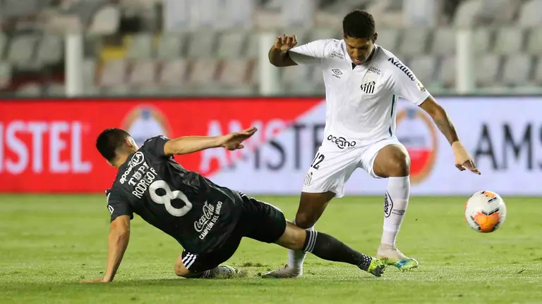 Raniel (d) de Santos disputa un balón ante Juan Rodrigo Rojas (i) de Olimpia hoy, durante un partido del grupo G de la Copa Libertadores, entre Santos de Brasil y Olimpia de Paraguay, en el estadio Urbano Caldeira de Santos (Brasil). EFE