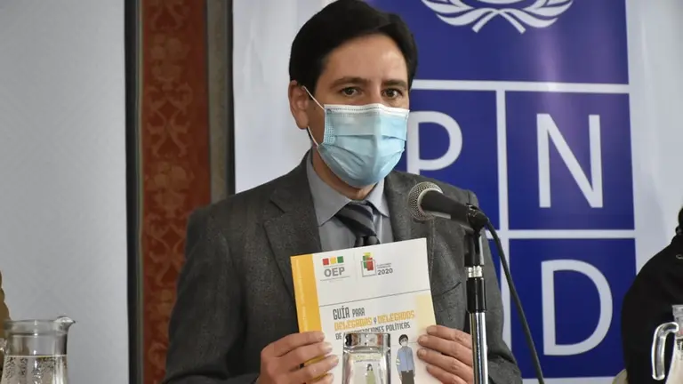 El presidente del Tribunal Supremo Electoral, Salvador Romero muestra una cartilla. APG
