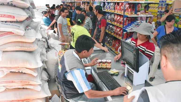 Un funcionario de Emapa atiende a los clientes en un supermercado estatal. Archivo