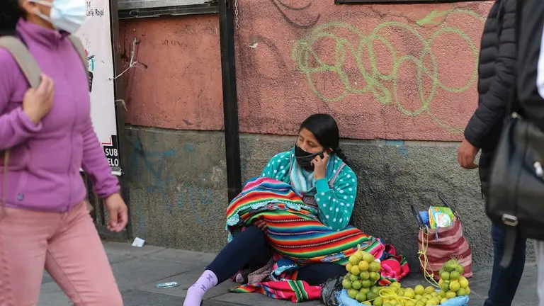 Una vendedora de limones ofrece su producto en el piso cerca de un mercado popular, el 7 de octubre de 2020, en el centro de La Paz (Bolivia). EFE