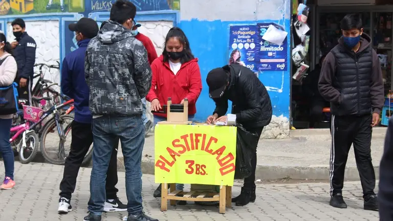 J&oacute;venes instalan servicio de plastificaci&oacute;n en cercan&iacute;as de los recintos electorales.  Peter Luna