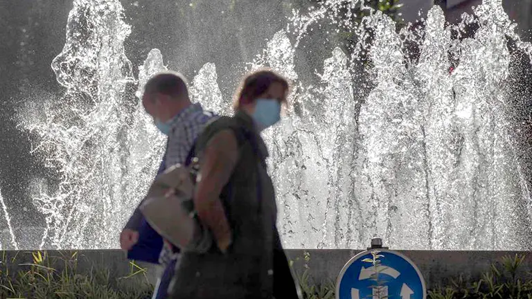 Dos personas pasan junto a una plaza en Oviedo (España). EFE