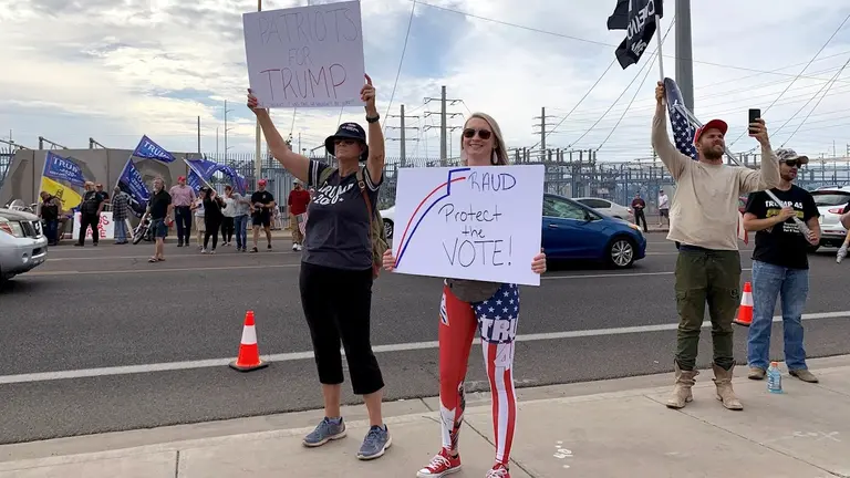Seguidores del presidente Trump sostienen pancartas y banderas durante una protesta este viernes en Phoenix, Arizona. EFE