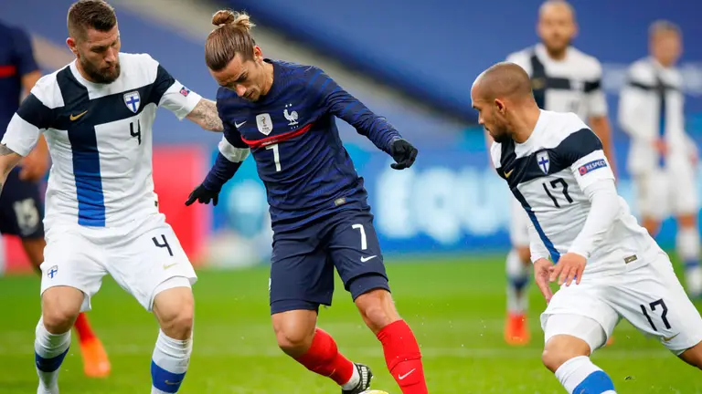 El francés Antoine Griezmann (C) y los finlandeses Joona Toivio (L) y Nikolai Alho (R) en acción durante el partido amistoso de fútbol entre Francia y Finlandia en París. EFE