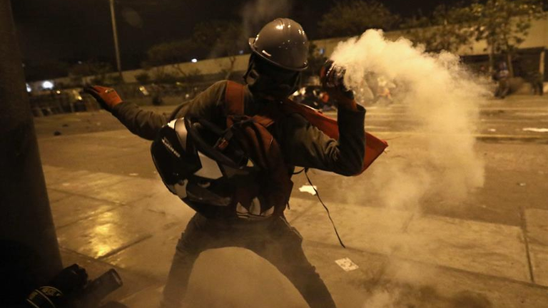 Polic&iacute;a y manifestantes se enfrentan durante una multitudinaria marcha de protesta contra el nuevo gobierno del presidente Manuel Merino, en Per&uacute;. EFE