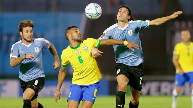 El jugador Edinson Cavani (d) de Uruguay disputa un balón con Renan Lodi de Brasil hoy. EFE
