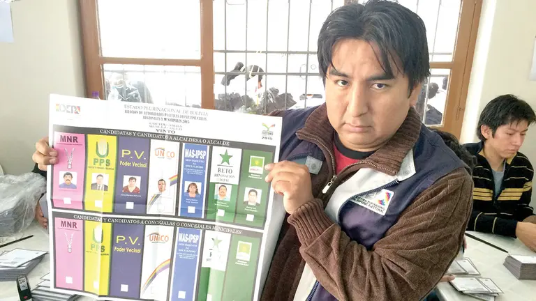 Un jurado electoral expone una papeleta en uno de los municipios de Cochabamba, en las elecciones de 2015.	 OPINIÓN