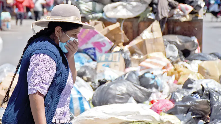 Una ciudadana pasa al lado de un contenedor que rebalsa basura en la ciudad. DICO SOLÍS