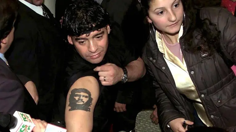 Foto de archivo muestra a Maradona mostrando un tatuaje del Che Guevara. EFE