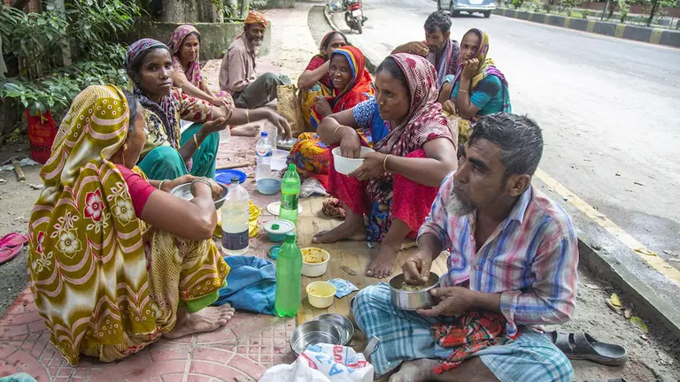 Una familia come en una calle de Bangladesh. EFE