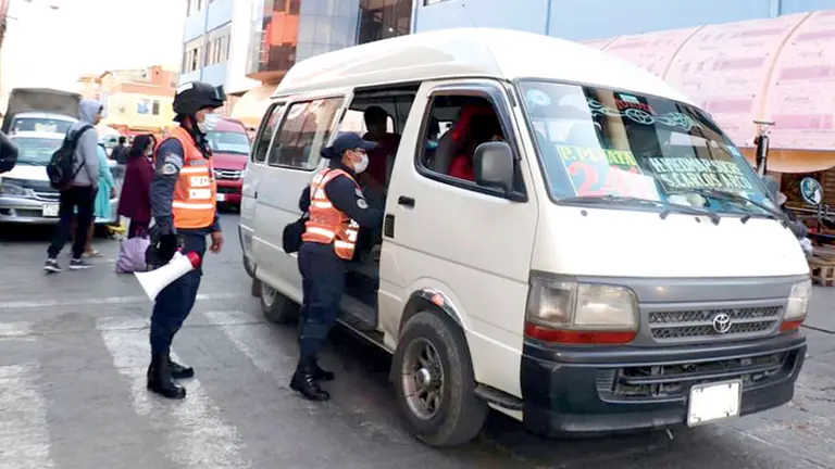 Guardias paran un auto de servicio público para controlar el uso de barbijo y la portación de alcohol en gel, en Sacaba. Archivo