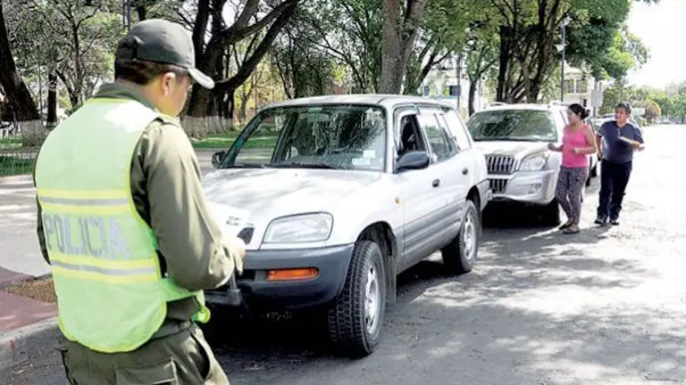 Un efectivo de Tr&aacute;nsito realiza una inspección de un veh&iacute;culo en Cochabamba.